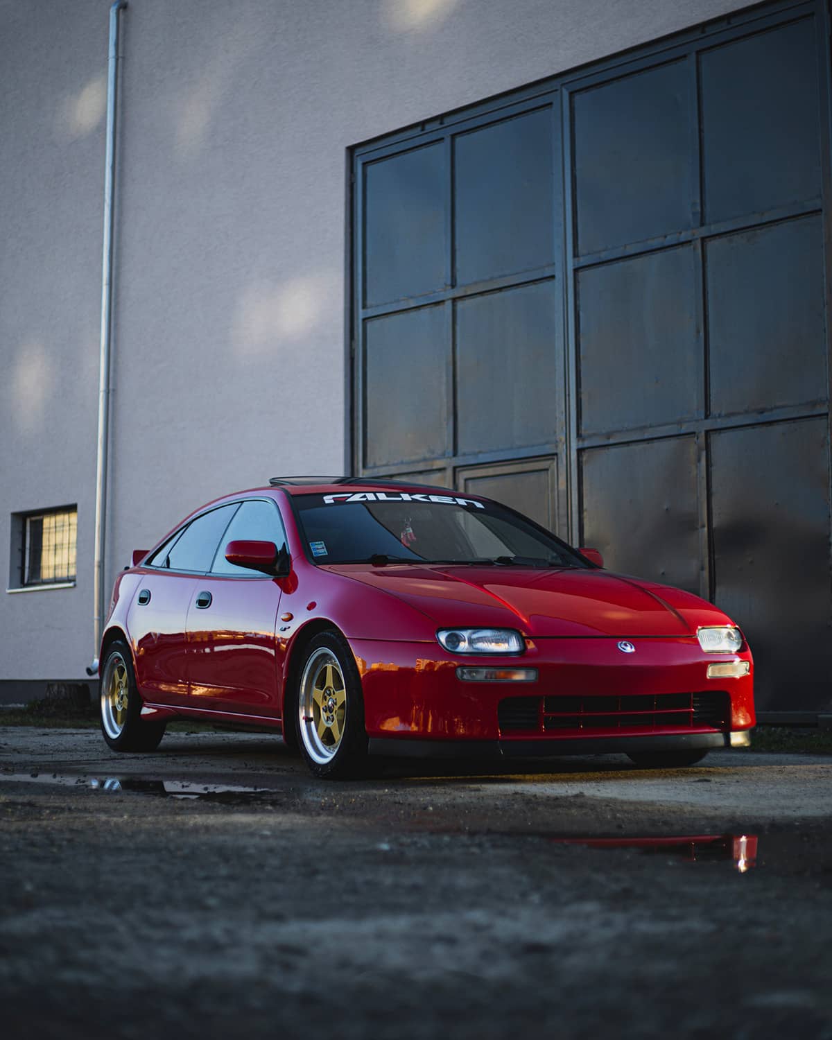 Red Mazda 323F with custom wheels